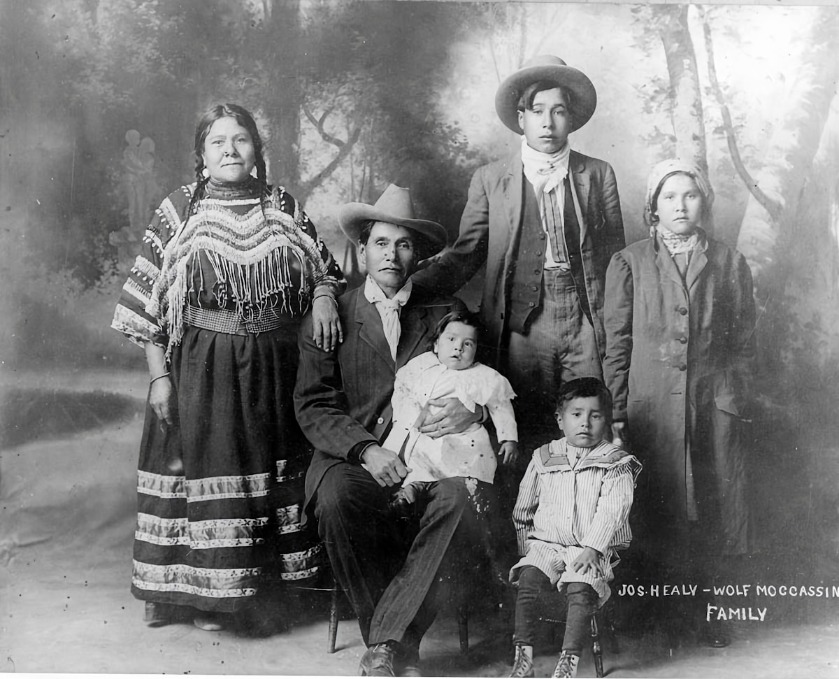 A worn black-and-white family photograph held in two hands
